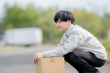 しゃがむ作業服男性