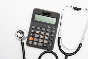 Calculator and stethoscope on white background health medicine theme with copy space. Health care costs or medical insurance.