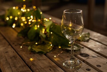Wine glass on a rustic table with fairy lights.
