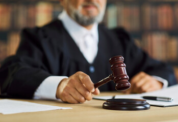 Gavel in hand of judge as symbol of legal justice and law in courtroom. Closeup of magistrate hand...