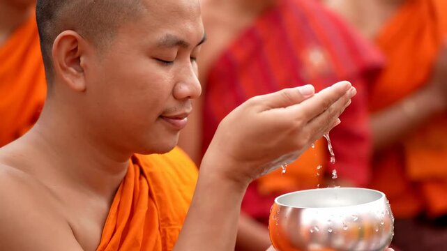 Close up monk blessing devotees holy water cinematic UHD Songkran cultural tradition stock video. cleric sanctification follower sacred liquid filmic ultra high definition thai