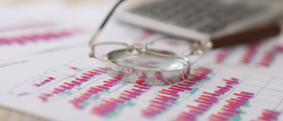 Eyeglasses & Magnifying Glass on Financial Charts