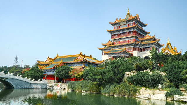 Traditional Chinese temple in Penglai, Shandong, with red pillars, golden roofs, and ornate details, surrounded by lush greenery and a serene natural setting.