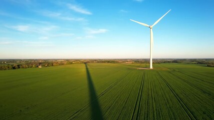 Wind turbine shadow stretching farmland cinematic UHD renewable green energy stock video. windfarm silhouette field movie ultra high definition sustainable power footage. - Powered by Adobe