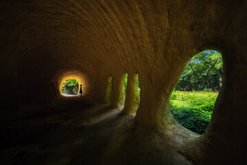 Underground Cave Tunnel System with Natural Window Openings and Lush Green Vegetation Views