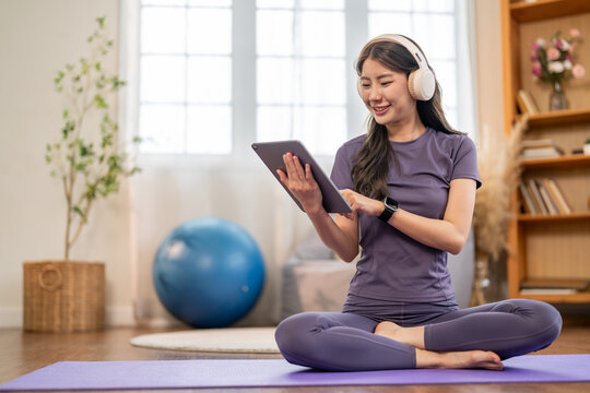 Asian woman relax using tablet at home, digital lifestyle with social media, online shopping, mobile banking, remote work and ecommerce service, fintech application and digital finance engagement - Powered by Adobe