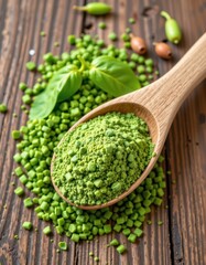 Close up of bright green pea powder and dried split peas on wooden spoon and wooden surface with scattered peas and beans, fresh organic vegetable ingredient