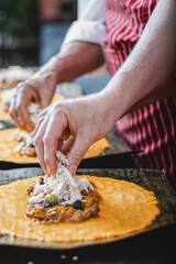 Adding a slice of red pepper to the filling of a Venezuelan hallaca