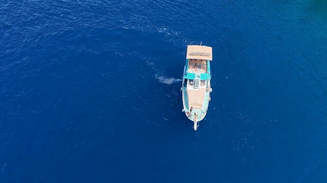 An aerial drone video of a classic wooden gulet style tour boat cruising on the beautiful deep blue sea a traditional and luxurious way to travel and explore the coast