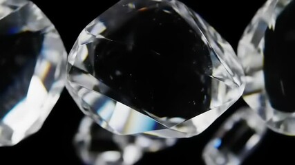 Close-up of sparkling clear faceted crystals or diamonds rotating against a black background - Powered by Adobe