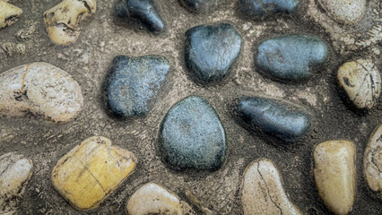 Smooth pebbles background featuring a variety of natural stones in different shapes, colors, and...