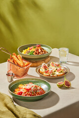 Delicious Mediterranean Meal Pasta, Figs, and Fries on a Rustic Table Setting