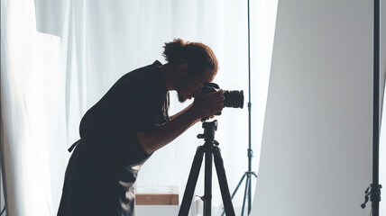 Professional photographer adjusting camera in studio setting, focused and dedicated