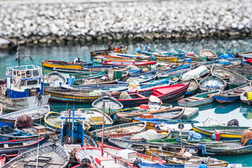 Colorful wooden fishing boats are tightly moored together in Callao, Peru. 