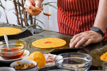 Sprinkling annatto oil on corn dough for hallacas