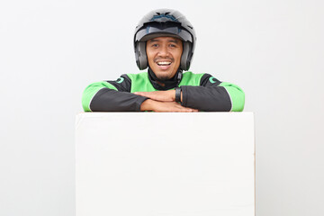 Happy asian online driver smiling looking at the camera while leaning on blank board below him