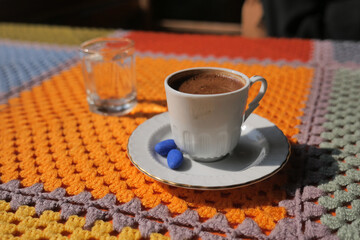 Warm turkish coffee served on a colorful knitted tablecloth