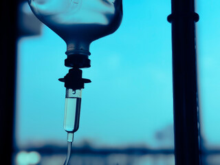 Medical infusion pump with digital screen displaying flow rate in a hospital room. Pediatric patient resting in bed in the background. Healthcare and intravenous therapy concept.