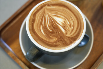 Cappuccino it's a mix between coffee and milk. Draw an artistic pattern on the cream foam.