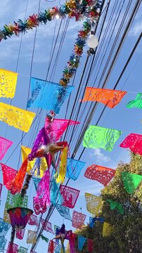 Colorful papel picado and pinatas decorating a street for christmas