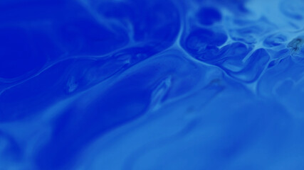 Ink spill. Acrylic pigment. Defocused liquid spreading on blue colorful chemical marble water on abstract creative background.