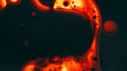 Lava volcanic. Emulsion flow. Defocused dark red orange glowing water paint liquid oil bubble...