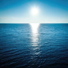 Obraz premium Vast ocean expanse under a vibrant blue sky, sun reflecting on the water's surface