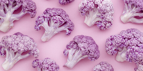 Purple cauliflower minimal aesthetic pattern on pastel pink, monochrome banner. Bright colored vegetable healthy food concept, textural view slices of broccoli, health diet product, trend food photo