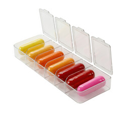 Clear plastic pill organizer filled with colorful capsules isolated on transparent background