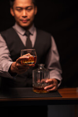 Bartender is pouring whiskey into a glass in a restaurant	