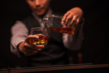 Bartender is pouring whiskey into a glass in a restaurant	
