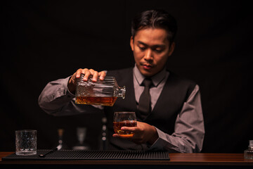 Bartender is pouring whiskey into a glass in a restaurant	