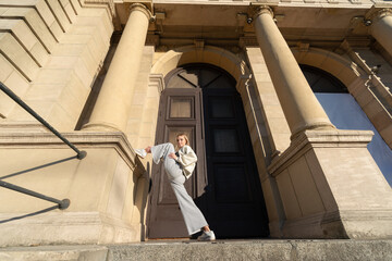 Young female posing on steps in front of an old building