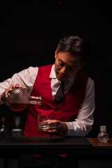 Bartender is pouring whiskey into a glass in a restaurant