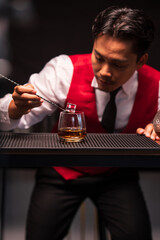 Bartender is pouring whiskey into a glass in a restaurant