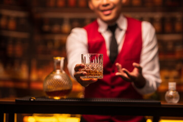 Bartender is pouring whiskey into a glass in a restaurant	