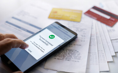 close up shot, man hand using mobile phone successfully paying credit card debt via mobile payment app