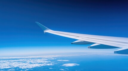 Fototapeta premium Airplane wing against blue sky