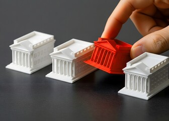 The hand places or removes the red bank among others. Liquidation of a bank due to lack of liquidity or financial crimes. Financial institution liquidation or banking sector recovery efforts concept.