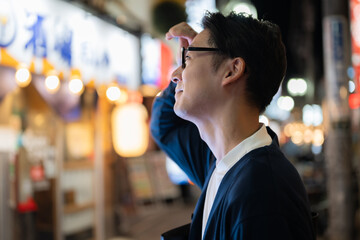 飲食店街を歩く男性