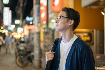 夜の街を歩く男性