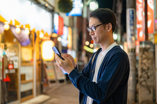 夜の街を歩く男性