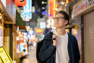 夜の街を歩く男性