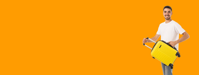 Young man smiles with a bright suitcase for adventure