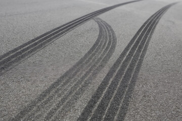 Tire marks asphalt surface create striking visual of speed and motion, showcasing aftermath of vehicle rapid movement. dark lines contrast sharply with gray pavement, evoking sense of excitement
