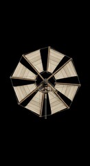 Detailed close-up of a vintage-style windmill, featuring light beige sails against a dark background.