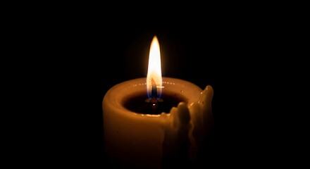 A single candle flickers warmly in the dark, casting a soft, comforting glow.