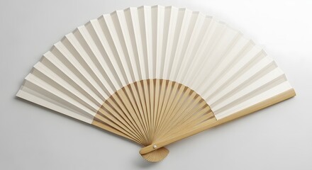 An open, folded hand fan with white paper and light brown wooden slats, on a plain surface.