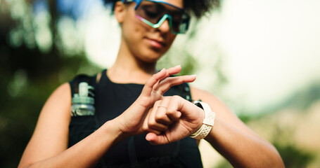 Fitness, running and watch with woman in forest for challenge, performance or progress tracking. Exercise, marathon and time with athlete or runner outdoor in nature for training or workout routine