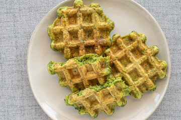Green waffles made of avocado on ceramic plate. Top view.